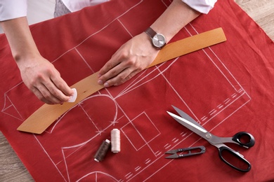 Tailor working at table in atelier, top view