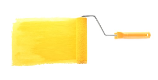 Photo of Applying yellow paint with roller brush on white background, top view