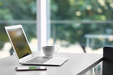 Comfortable workplace with modern laptop on desk in home office, space for text