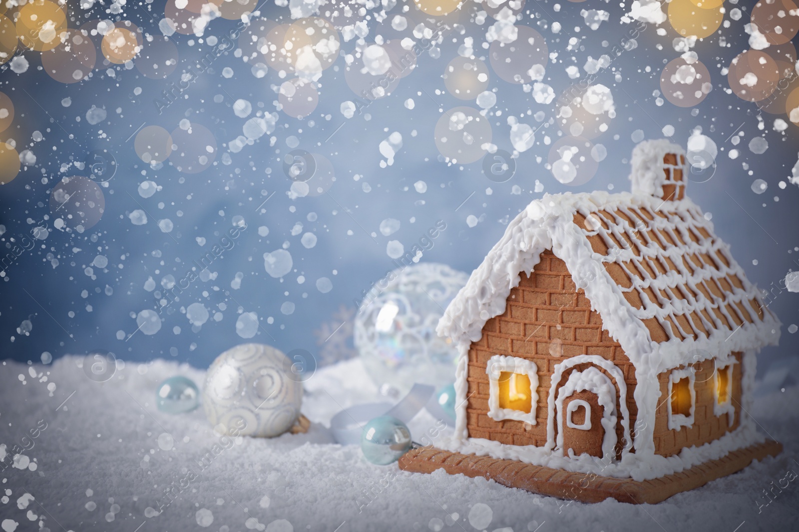 Image of Beautiful gingerbread house decorated with icing on snow, space for text