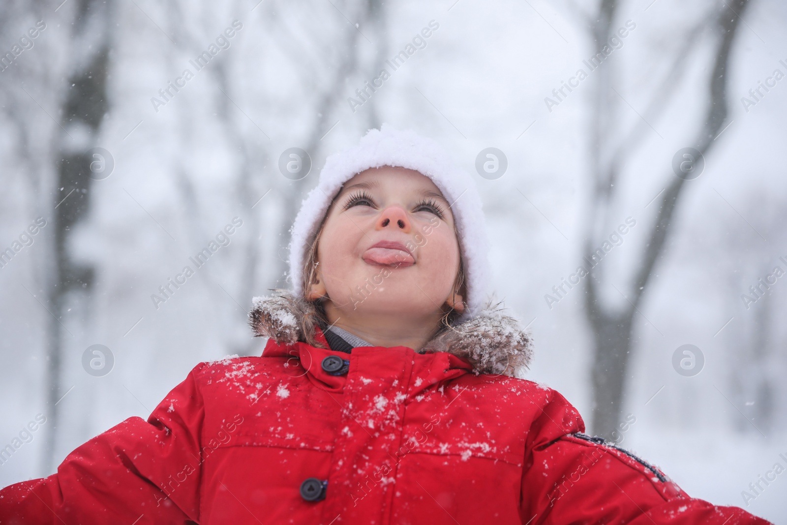 Photo of Cute little child having fun outdoors on winter day. Christmas vacation