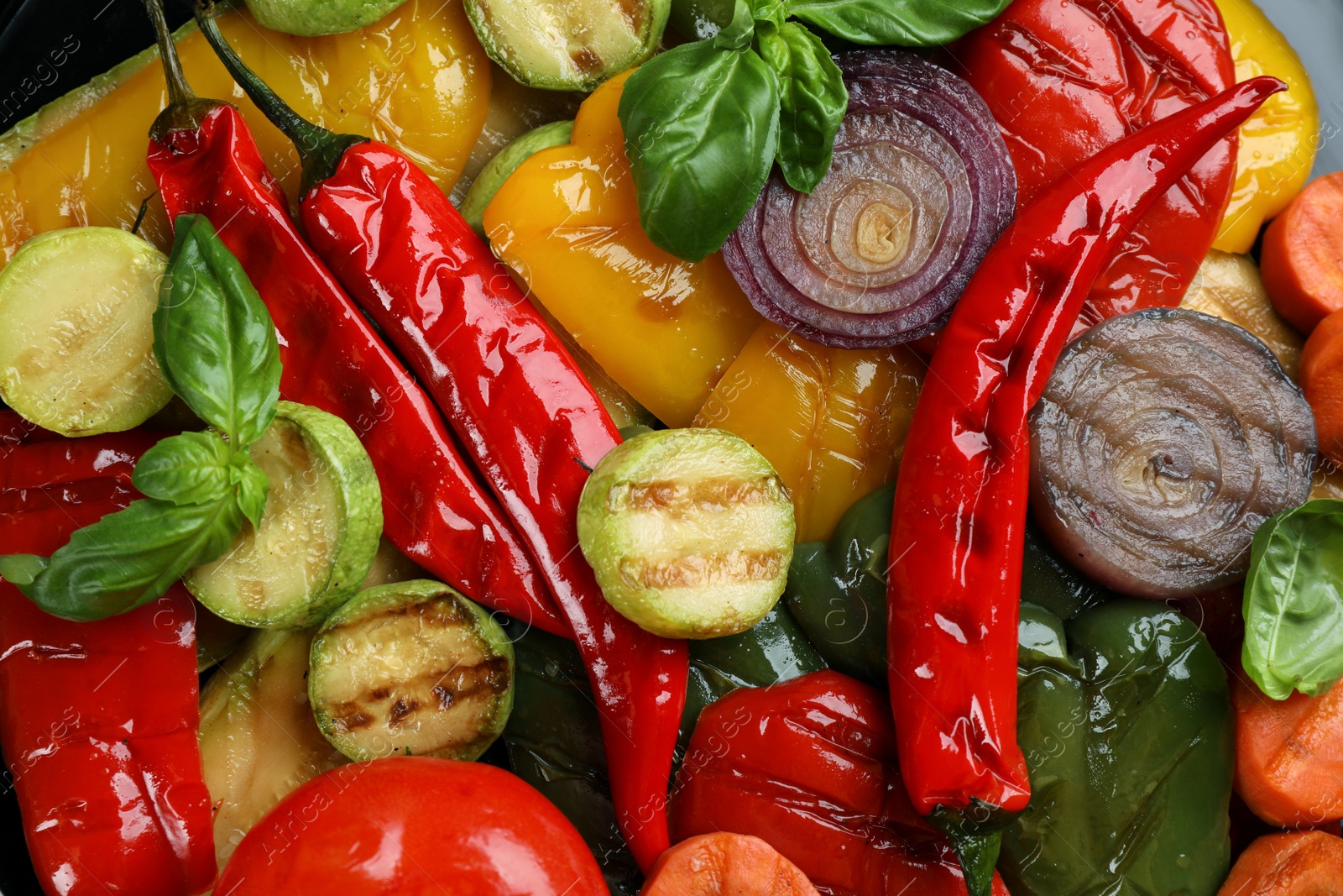 Photo of Delicious grilled vegetables with basil as background, closeup