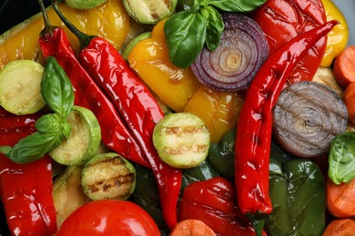 Delicious grilled vegetables with basil as background, closeup