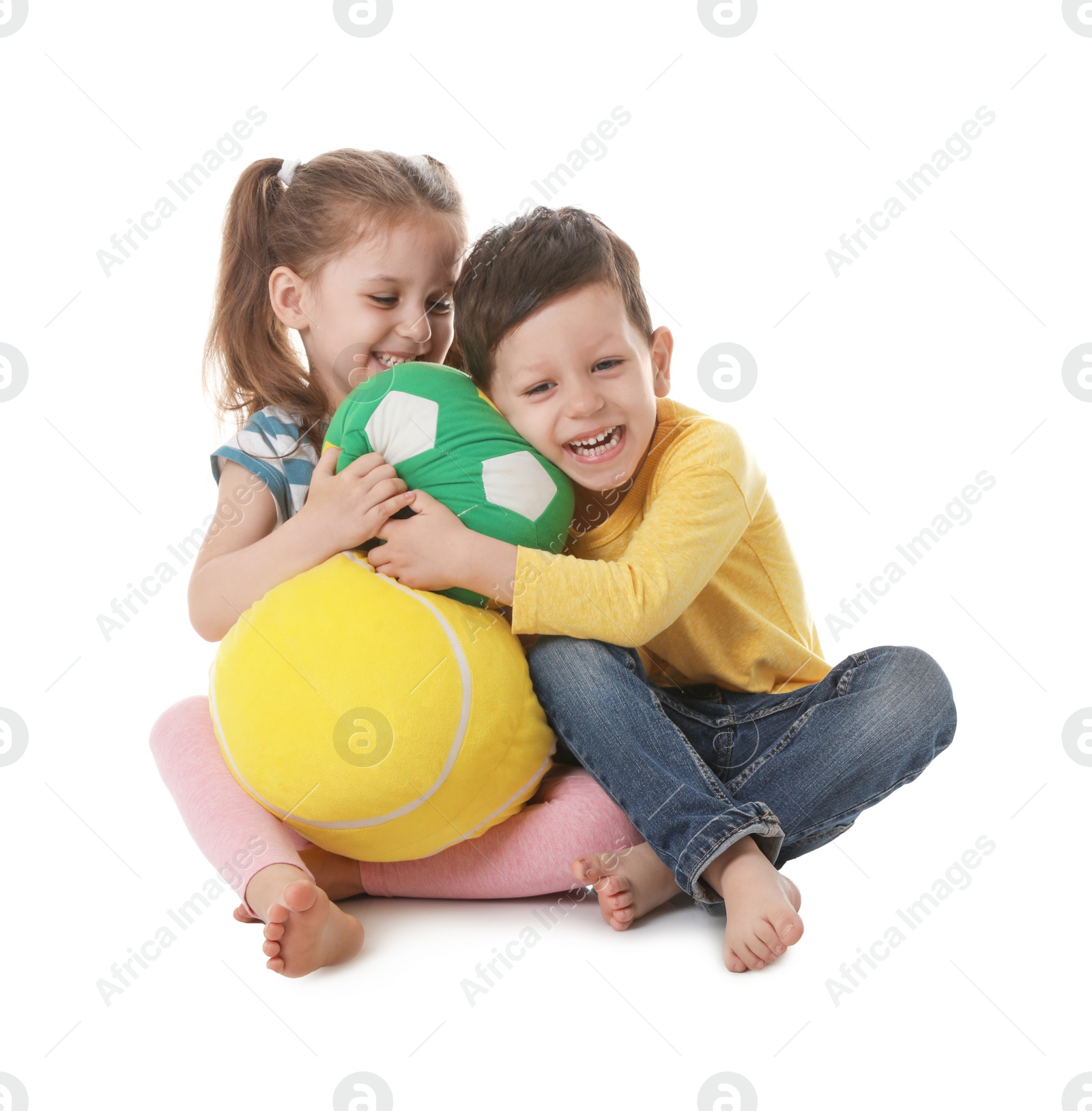 Photo of Cute little boy and girl with soft balls on white background