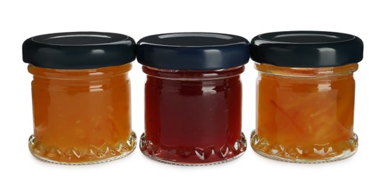 Jars with different jams on white background