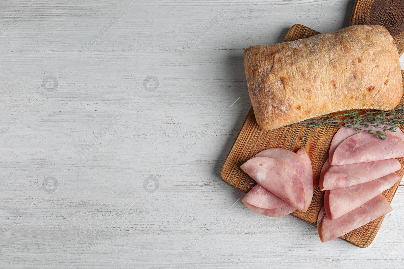 Photo of Tasty ham served on white wooden table, flat lay. Space for text