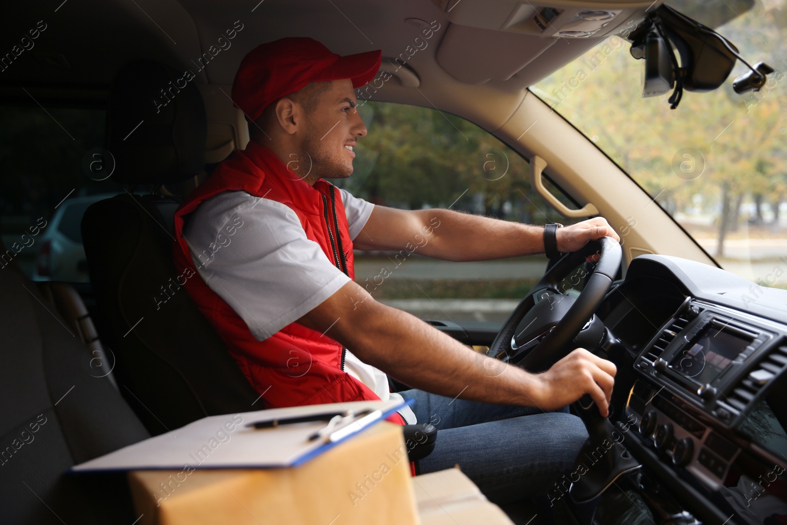 Photo of Courier in uniform on driver's seat of car