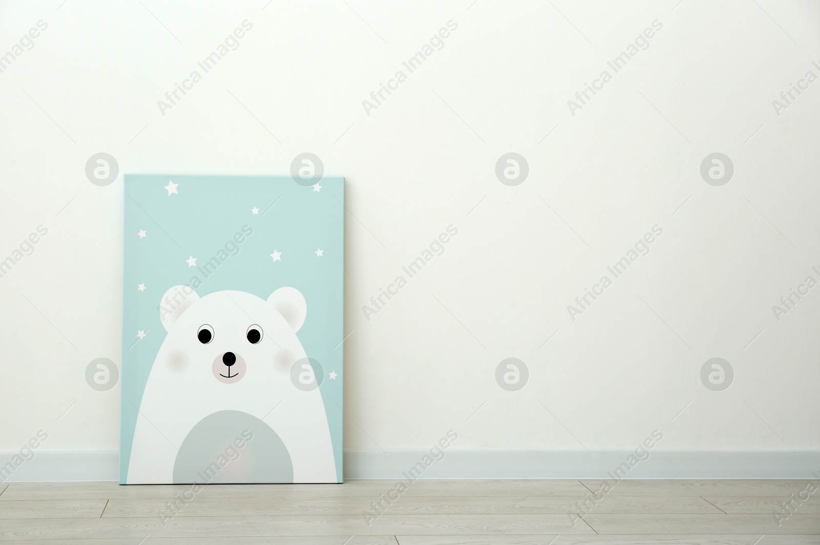 Photo of Adorable picture of bear on floor near white wall, space for text. Children's room interior element