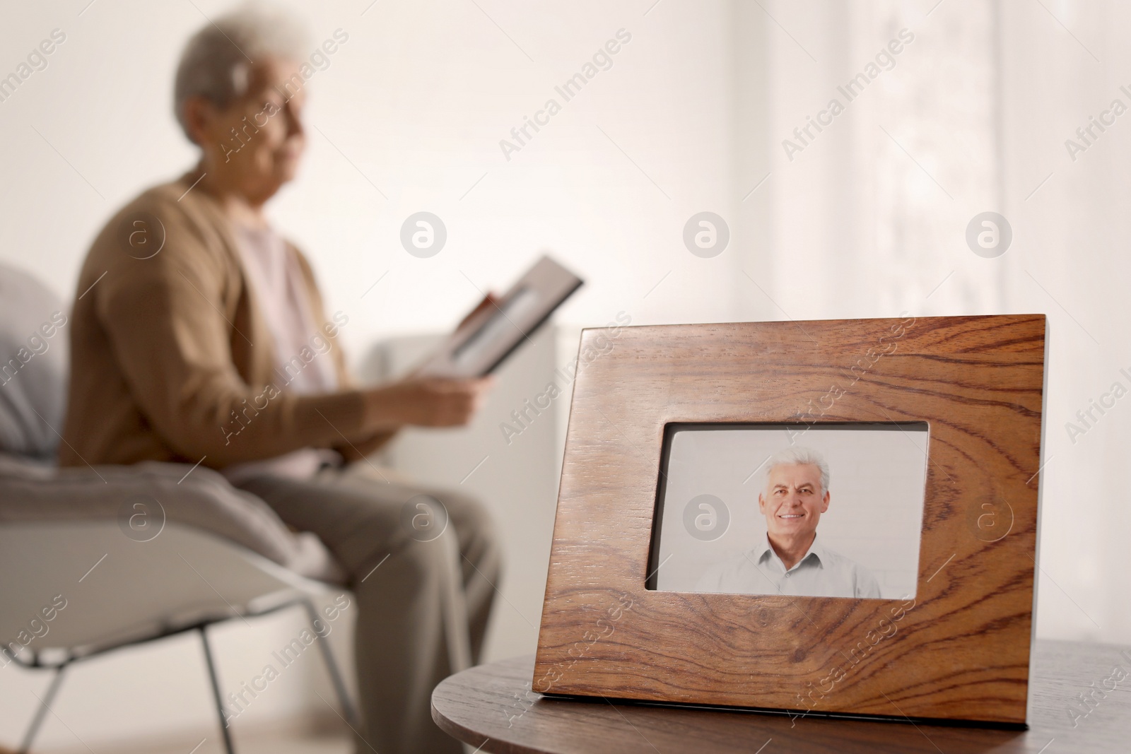 Photo of Framed photo of man and blurred female pensioner on background. Space for text