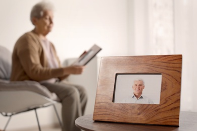 Framed photo of man and blurred female pensioner on background. Space for text