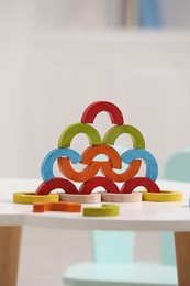 Colorful wooden pieces of playing set on white table indoors. Educational toy for motor skills development