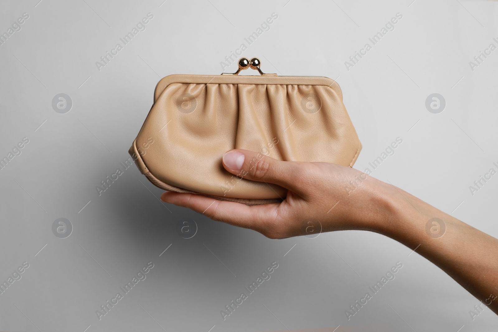 Photo of Woman holding leather purse on light background, closeup