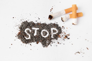 Photo of Word Stop made of cigarette ash and stubs on white background, flat lay. Quitting smoking concept