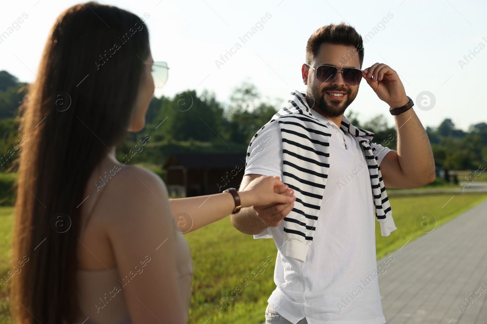 Photo of Romantic date. Beautiful couple walking in park on sunny day