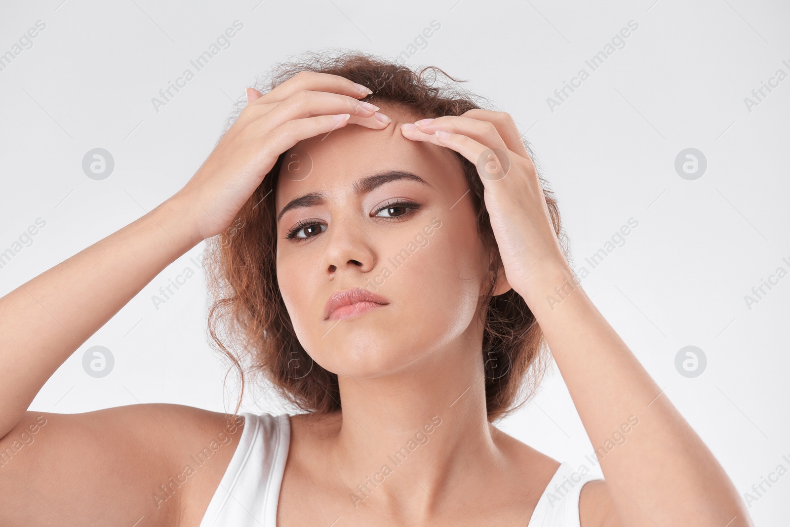 Photo of Beautiful young woman with acne problem on light background