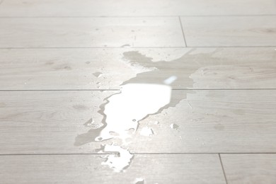 Photo of Puddle of spilled water on white laminated floor