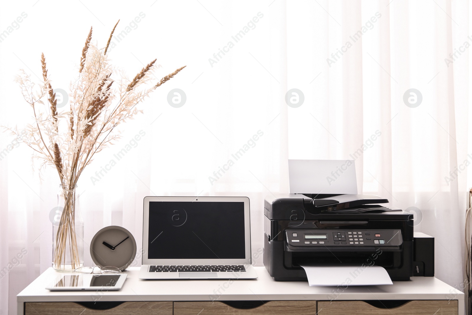 Photo of Modern printer, laptop and office supplies on white table indoors