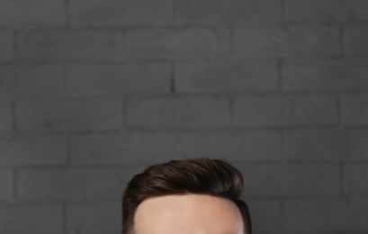 Man with beautiful hair on brick wall background, closeup