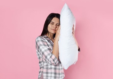 Photo of Sleepy young woman with soft pillow on pink background