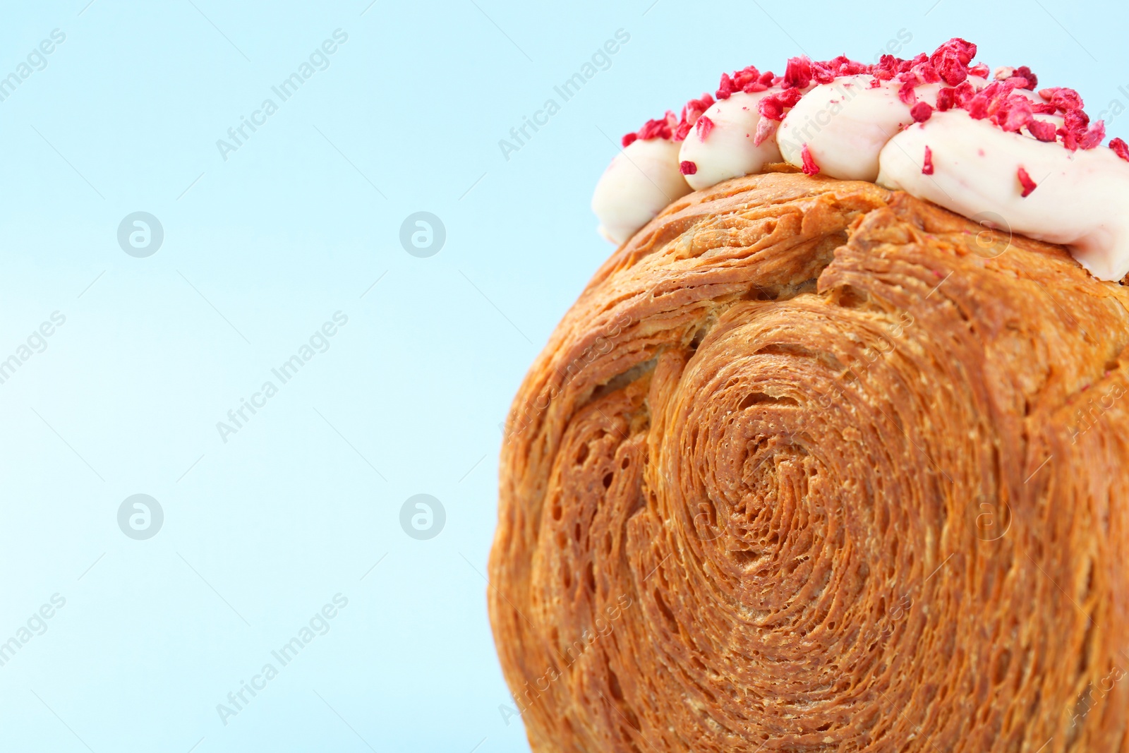 Photo of One supreme croissant with cream on light blue background, closeup with space for text. Tasty puff pastry
