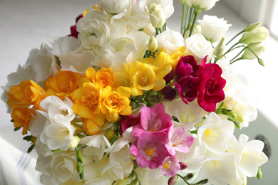 Beautiful bouquet with fresh freesia flowers on light background, closeup