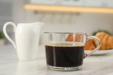 Photo of Aromatic coffee in glass cup on white marble table