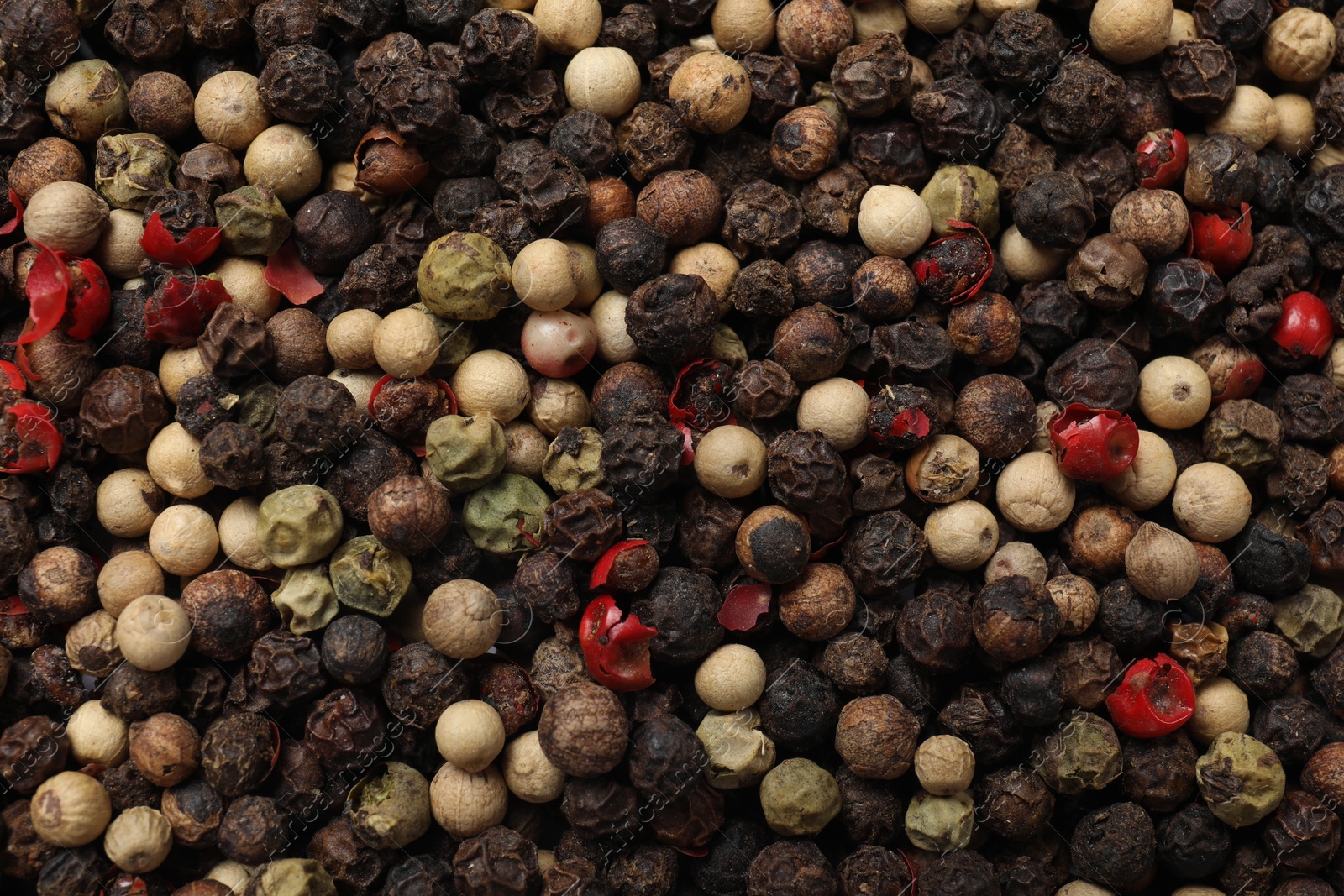 Photo of Aromatic spices. Different peppers as background, top view