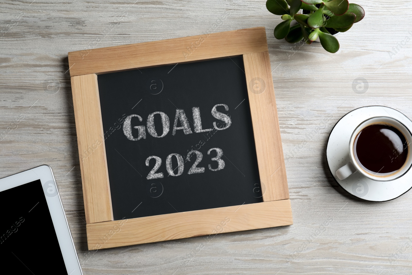 Image of Blackboard with phrase GOALS 2023 on wooden background, flat lay