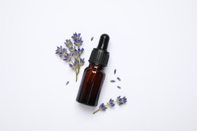 Composition with lavender flowers and natural essential oil on white background, top view