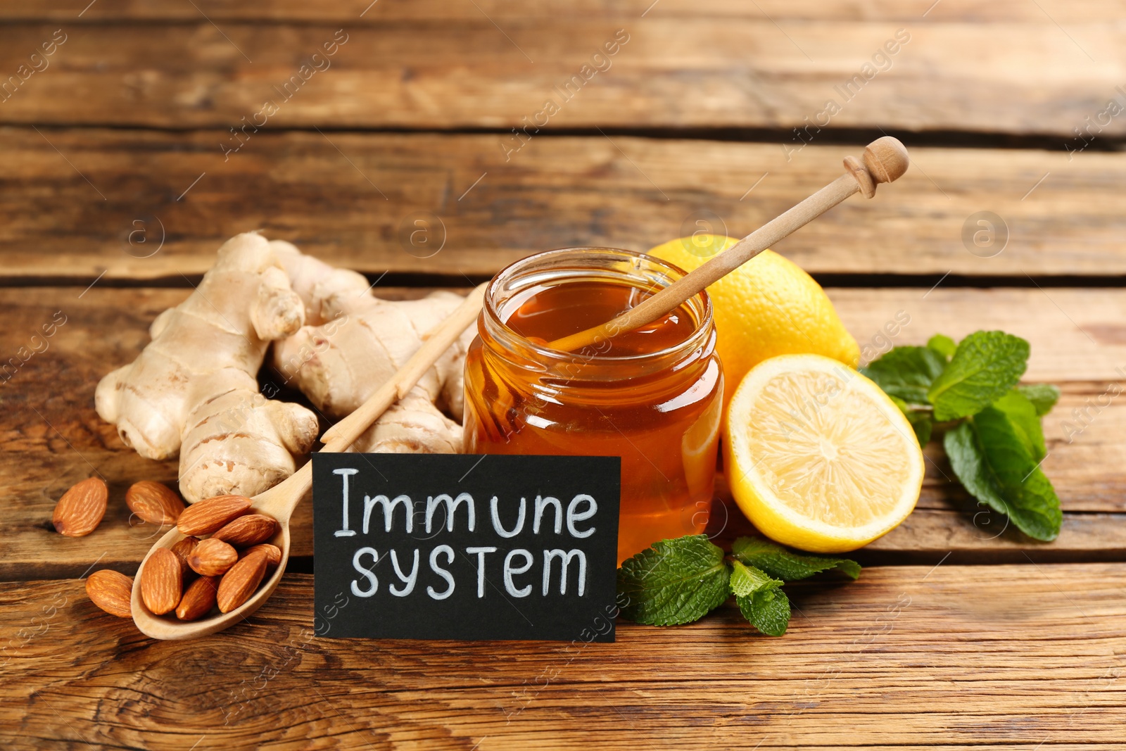 Photo of Card with phrase Immune System and fresh products on wooden table