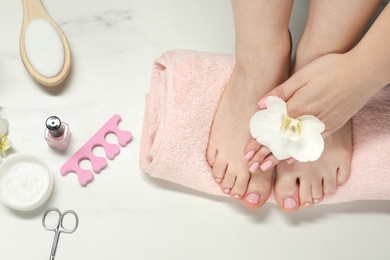 Closeup of woman with neat toenails after pedicure procedure on white background, top view