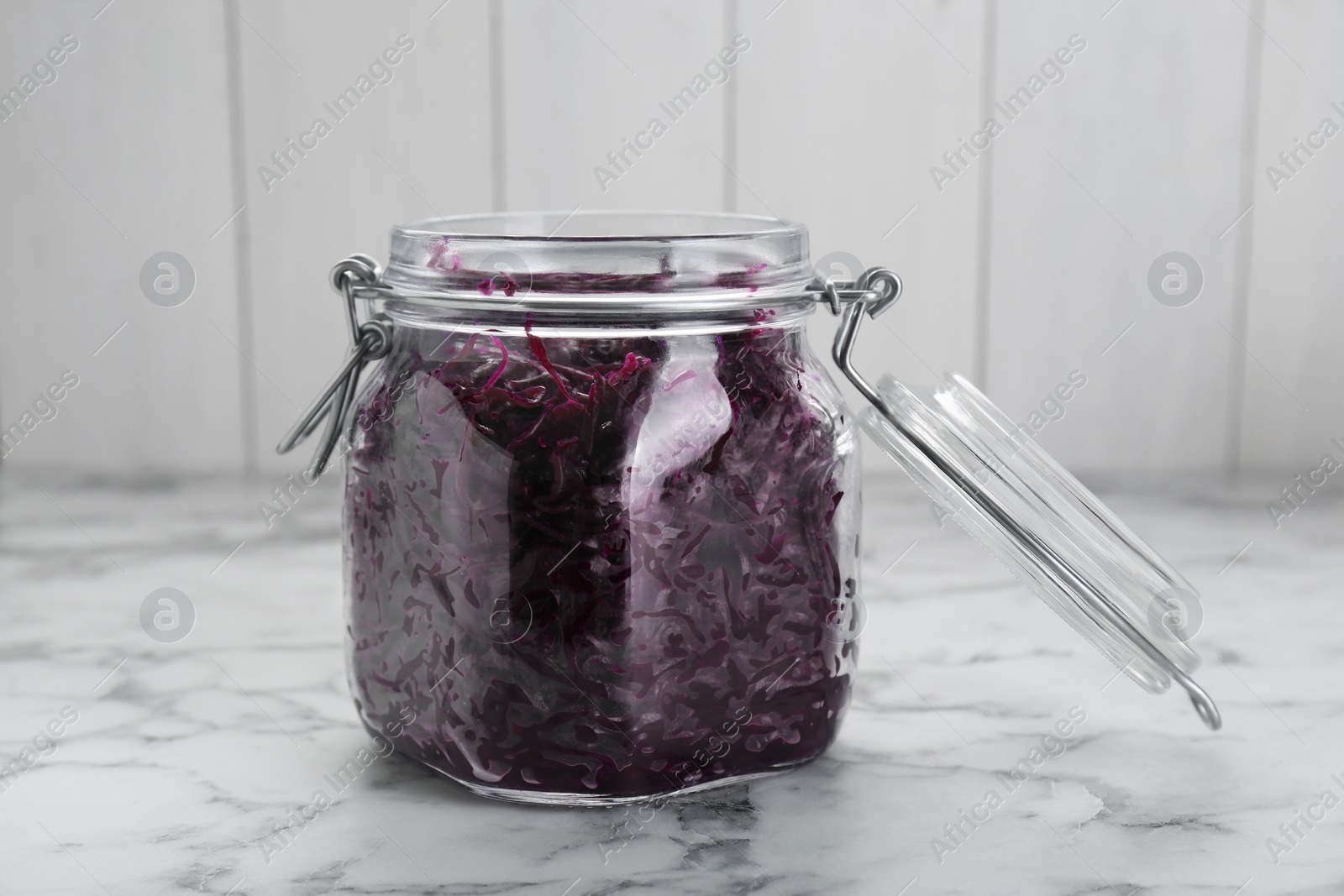 Photo of Tasty red cabbage sauerkraut on white marble table