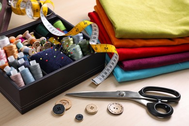 Photo of Set of sewing supplies and accessories on wooden table