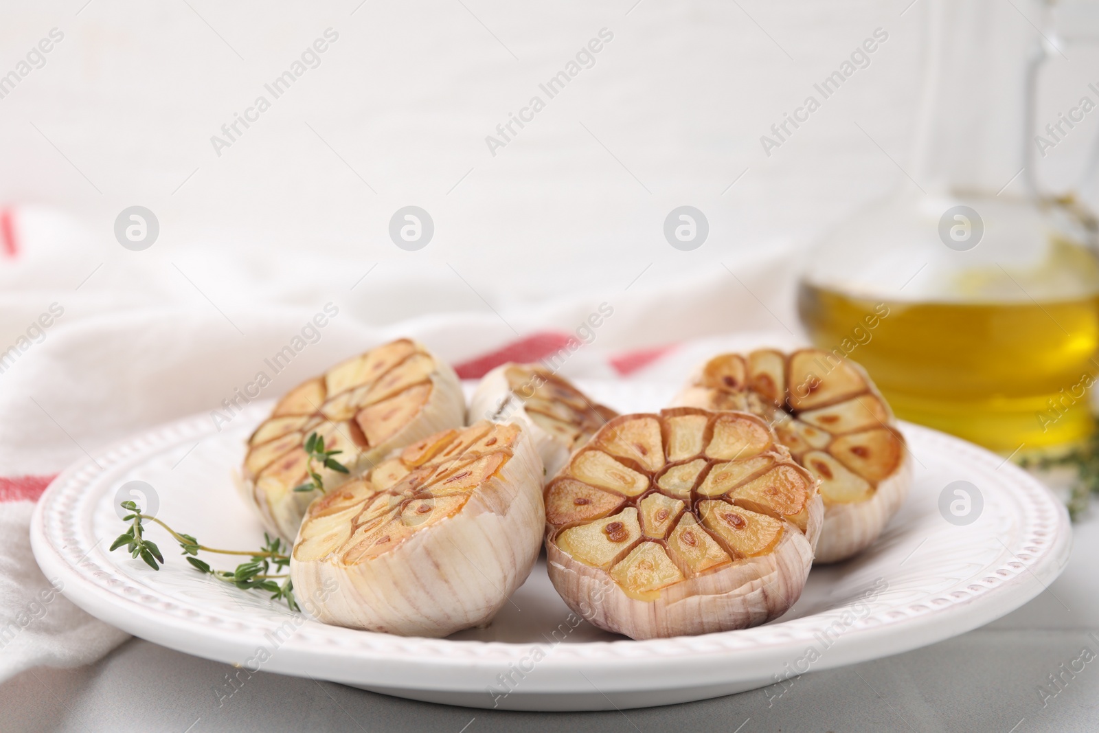 Photo of Heads of fried garlic and thyme on table, closeup. Space for text