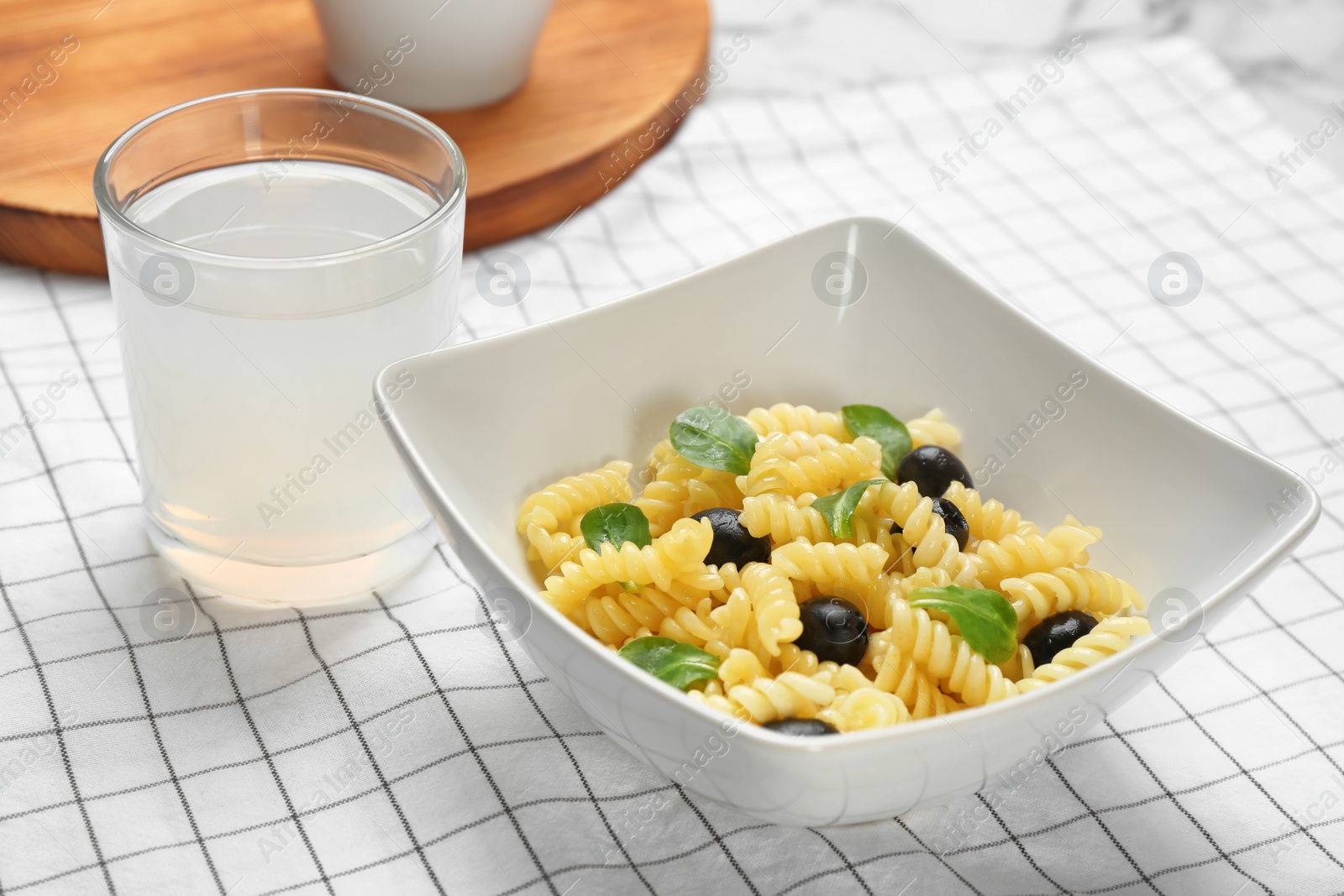 Photo of Bowl with delicious pasta salad on table