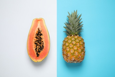 Photo of Fresh ripe papaya and pineapple on color background, flat lay