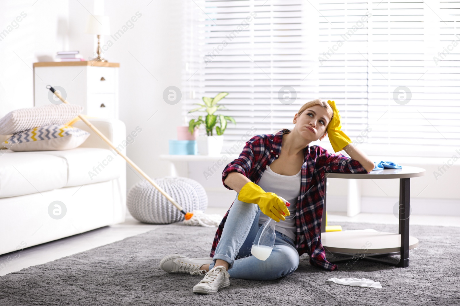 Photo of Lazy young woman wiping table at home. Cleaning and housework