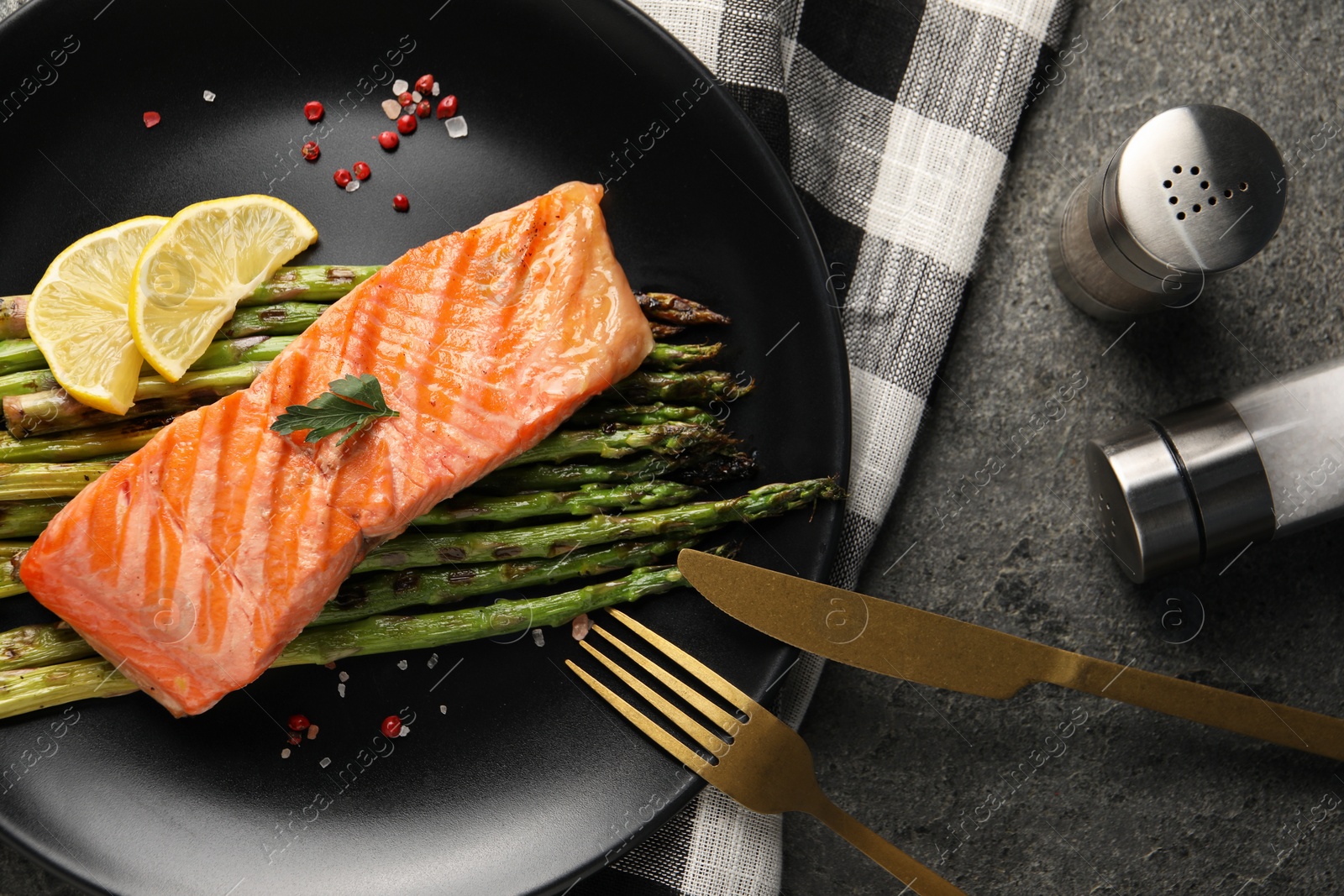 Photo of Tasty grilled salmon with asparagus, lemon and spices served on table, flat lay