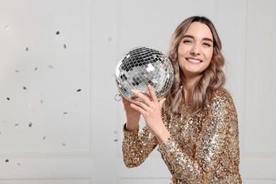 Photo of Beautiful woman in golden dress with disco ball posing on white background, space for text