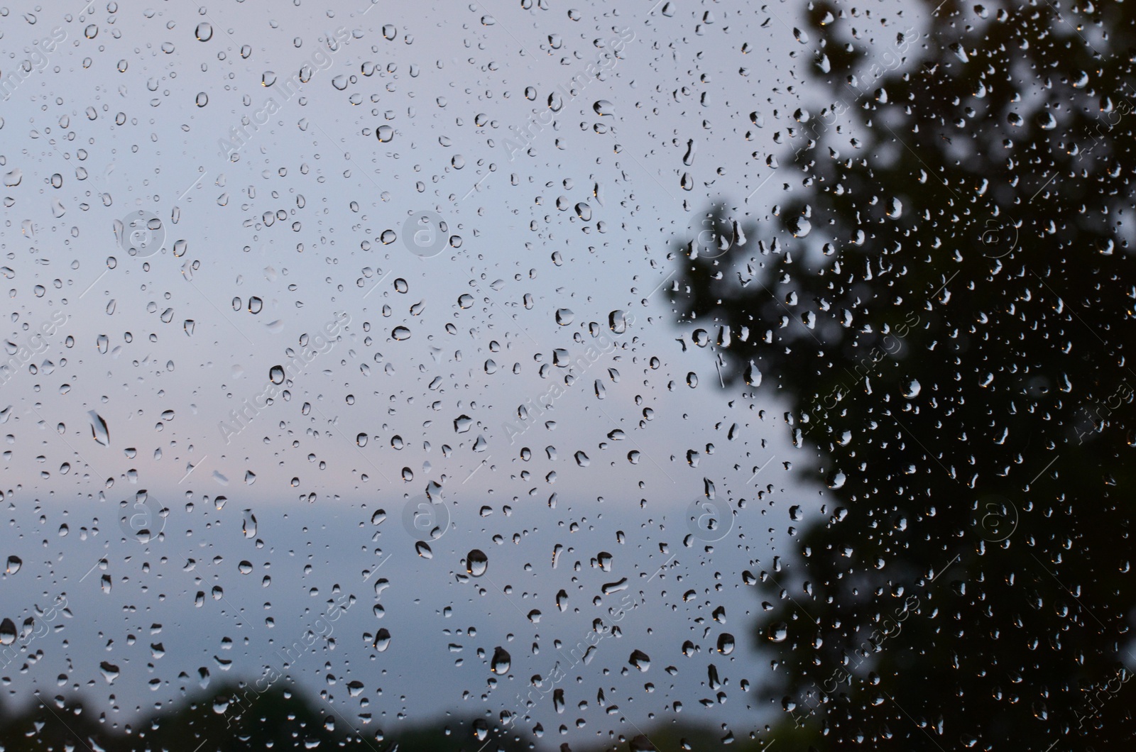 Photo of Window glass with water drops, closeup. Rainy weather