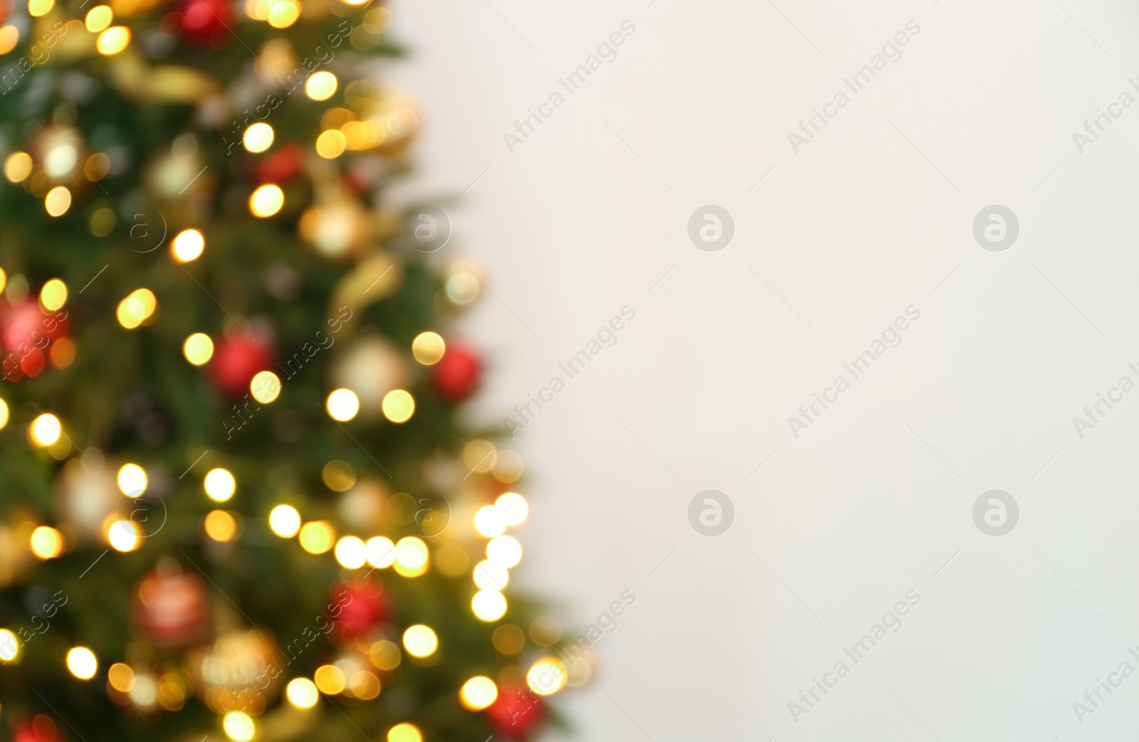 Photo of Blurred view of Christmas tree with fairy lights on white background