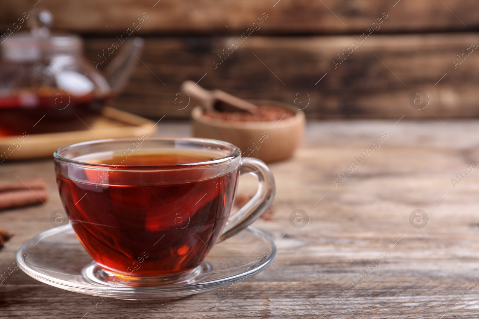 Photo of Freshly brewed rooibos tea on wooden table. Space for text