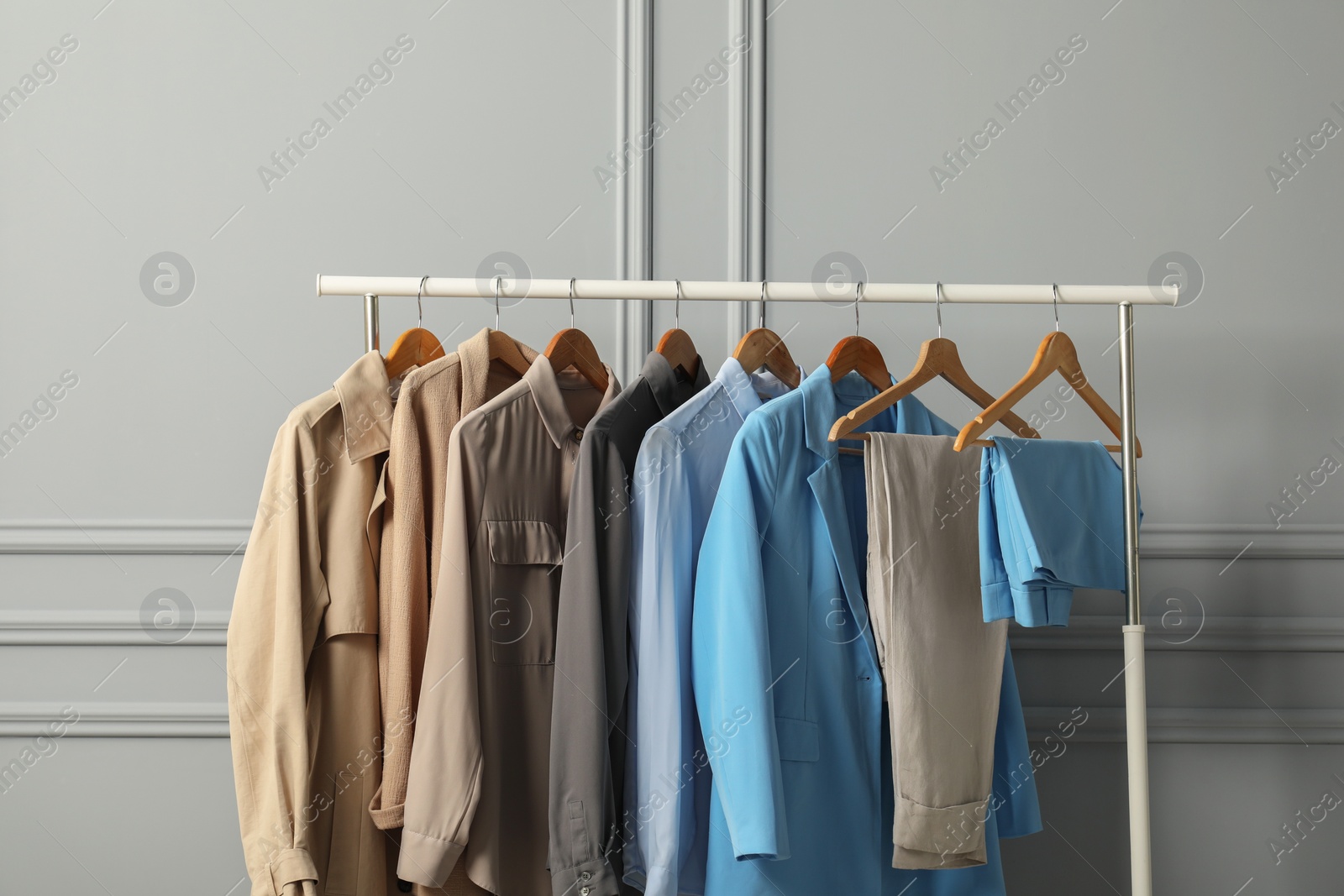 Photo of Rack with different stylish women`s clothes near grey wall