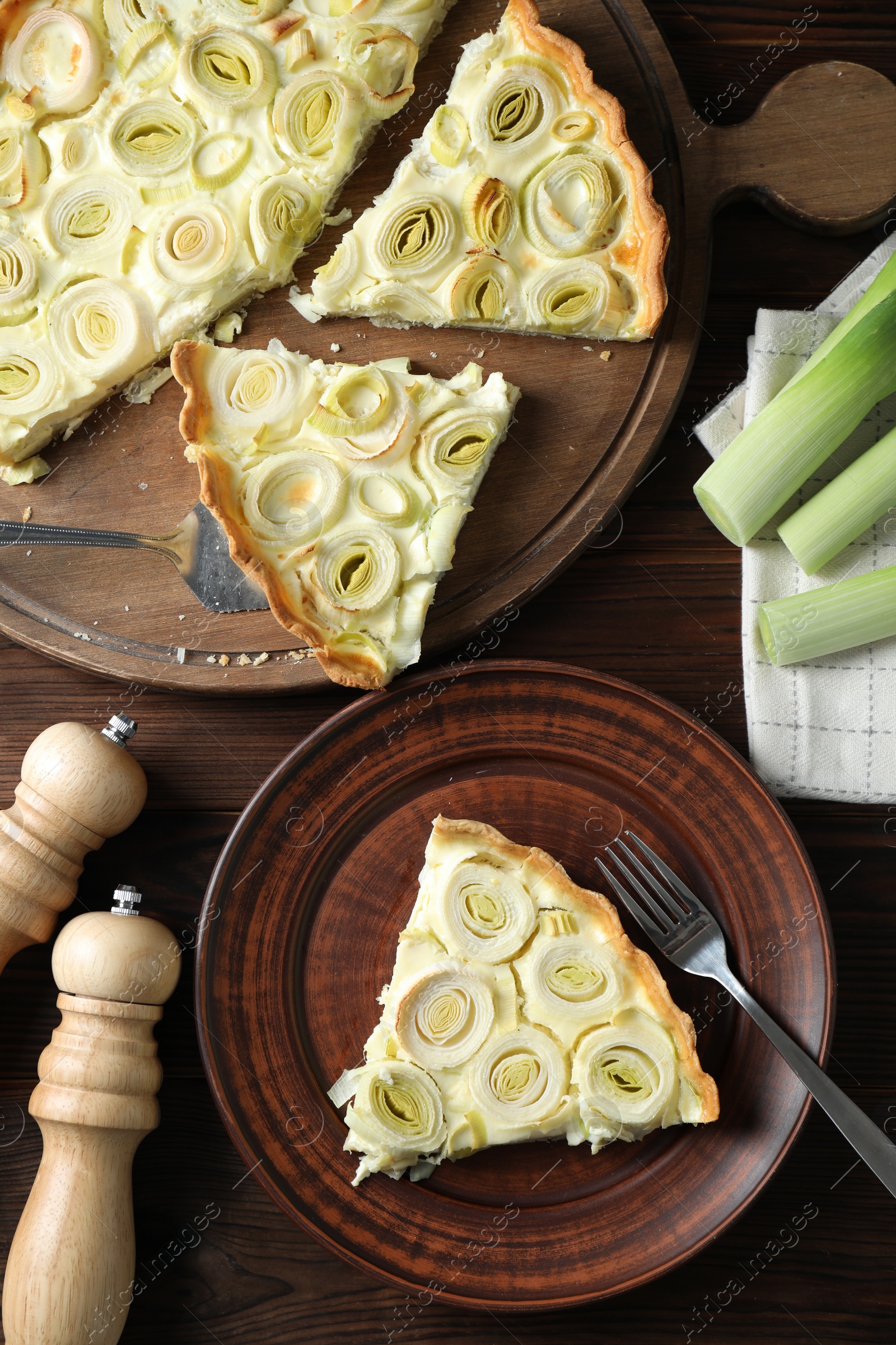 Photo of Tasty leek pie served on wooden table, flat lay