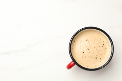 Photo of Cup of aromatic coffee on white table, top view. Space for text