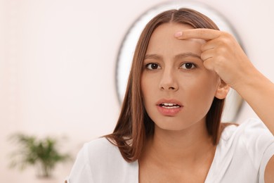 Woman with skin problem indoors, view from mirror