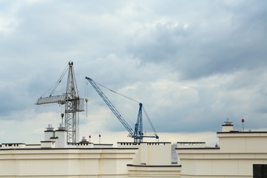 Photo of Construction site with tower cranes near building