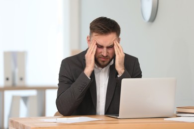 Image of Tired man with red eyes at workplace in office