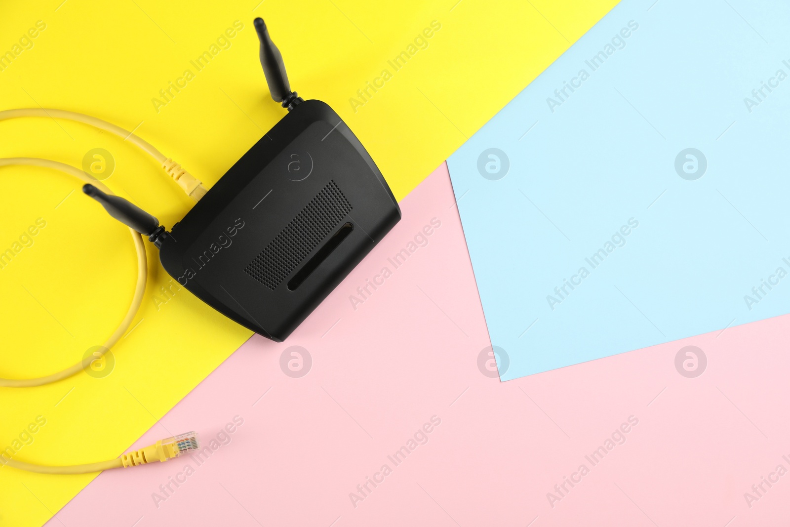 Photo of Modern Wi-Fi router on color background, top view. Space for text