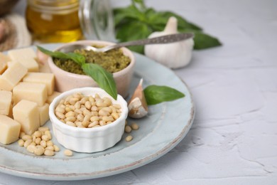 Photo of Tasty pesto sauce and ingredients on white table, closeup. Space for text